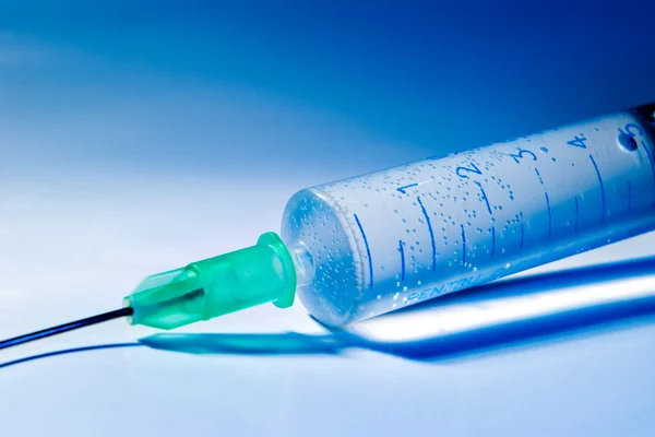 Syringe in blue light — Stock Photo, Image
