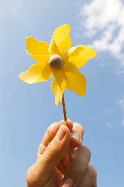 Mão com pinwheel amarelo — Fotografia de Stock