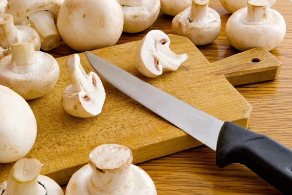 Mushrooms on the cutting board with knife — Stock Photo, Image