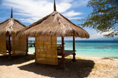 Hut at beach and turquoise sea on island, Gili Islands clipart