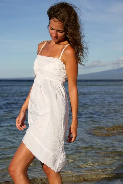 stock image Beautiful woman at beach with white dress and brown hair