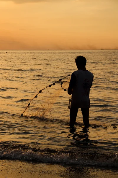 stock image Fisherman at beach with fishing net during sunset