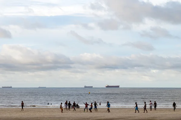 Jovens jogando futebol na praia — Fotografia de Stock