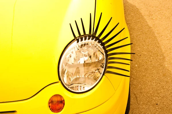 노란색 작은 자동차의 속눈썹과 재미 있는 램프. — 스톡 사진