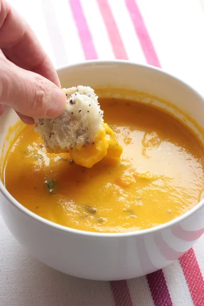 Dipping bread into soup — Stock Photo, Image