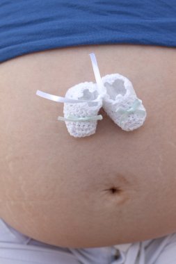 Baby boy socks on belly of pregnant woman