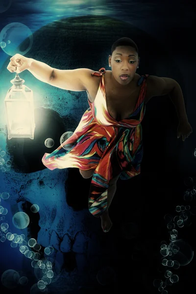 Linda mulher negra nadando debaixo d 'água com lanterna — Fotografia de Stock