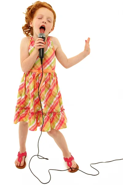 마이크에 노래 하는 귀여운 아이 스톡 사진