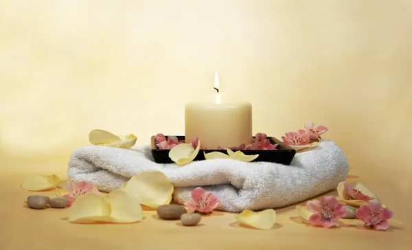 Handtuch mit Kerze und Blütenblättern — Stockfoto
