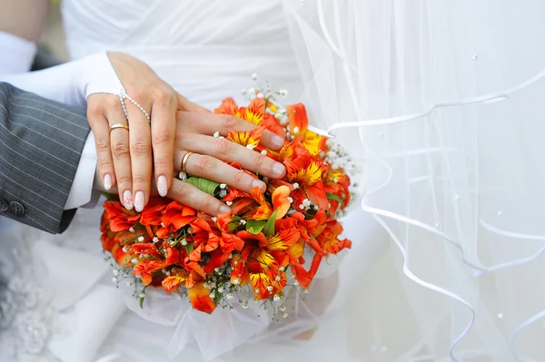婚礼花束上的手和戒指 — 图库照片