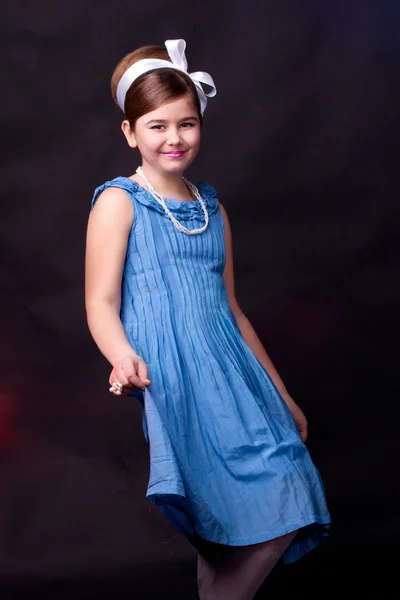Een schattig meisje in blauwe jurk — Stockfoto