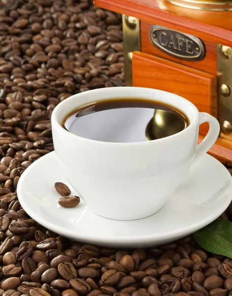 Cup of coffee with beans on wood background — Stock Photo, Image