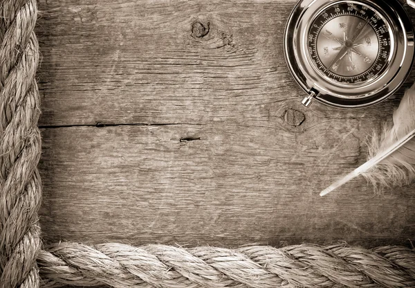 Cuerdas de barcos y brújula sobre madera vieja — Foto de Stock