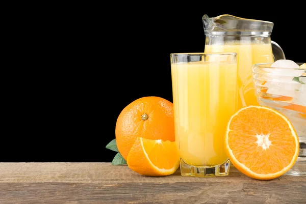 Свежий апельсиновый фруктовый сок и ломтики изолированы на черный — стоковое фото