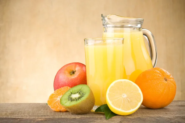 Färsk frukt juice i skivor på trä och glas — Stockfoto