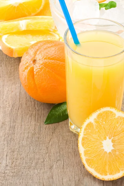 stock image Orange juice and slices fruit on wood