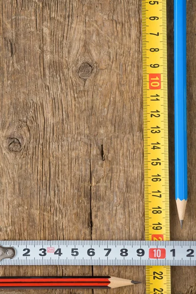 Pencil and tape measure on wood — Stock Photo, Image