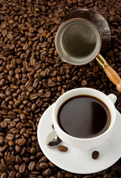 Tasse Kaffee und Kanne mit Bohnen — Stockfoto