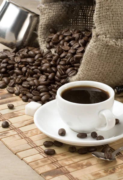 Tasse Kaffee, Bohnen und Sack auf Holz — Stockfoto