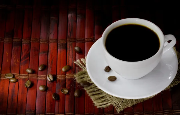 Cup of coffee with beans on wood — Stock Photo, Image