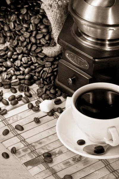 Tasse Kaffee und Mühle mit Bohnen — Stockfoto