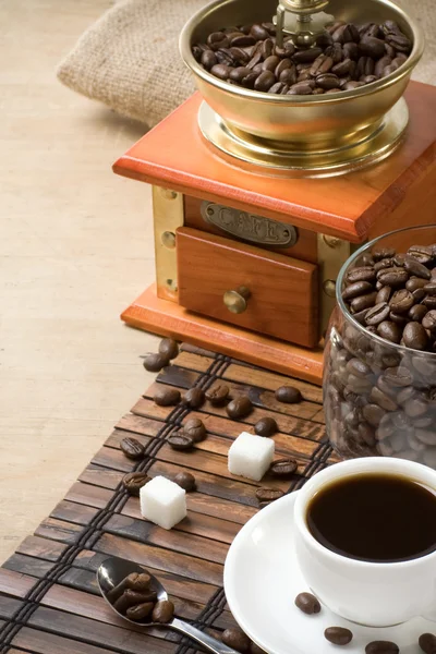 Xícara de café e moedor com feijão — Fotografia de Stock