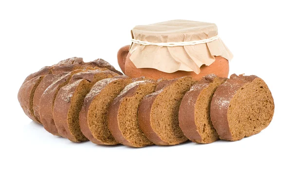 Буханка хлеба и горшок на белом — стоковое фото