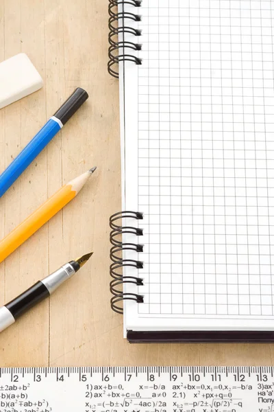 Caneta, lápis e caderno sobre madeira — Fotografia de Stock