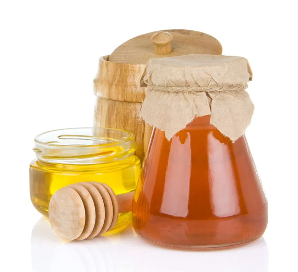 玻璃瓶里装满蜂蜜和棒子 — 图库照片
