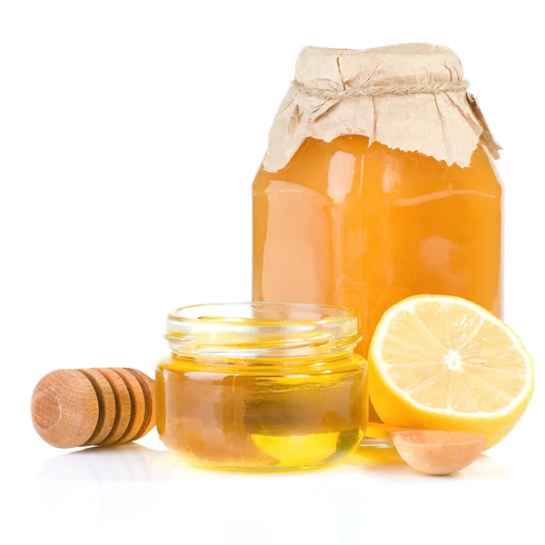 Frasco cheio de mel e limão sobre branco — Fotografia de Stock