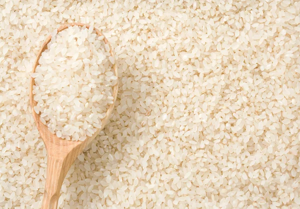 Ρύζι κόκκους φόντο και κουτάλι — Φωτογραφία Αρχείου