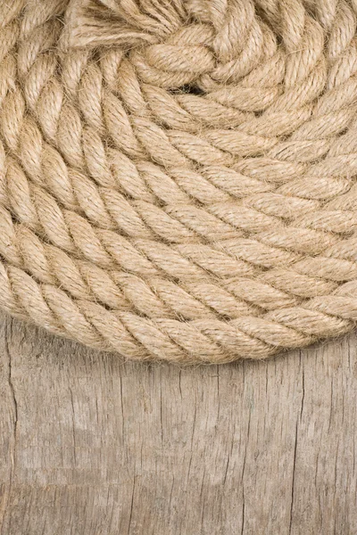 Судовые веревки и узел на деревянной текстуре — стоковое фото