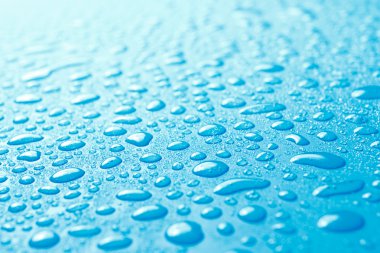 Close-up of fresh water drops on blue surface clipart