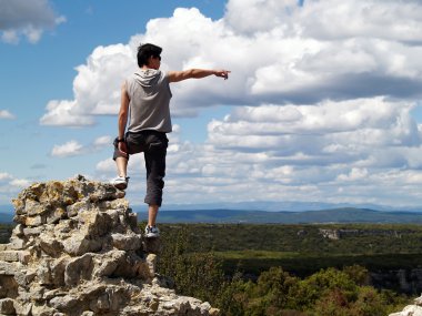 br sey işaret eden bir uçurumun kenarına duran uzun yürüyüşe çıkan kimse