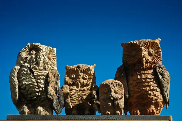 Familie van hout uilen op achtergrond blauwe hemel Rechtenvrije Stockafbeeldingen