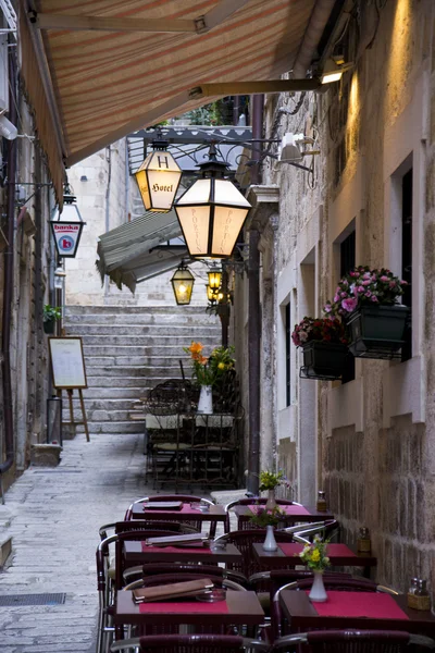 Enge Straße mit Blumen, Restaurant, Lampen und Treppen — Stockfoto