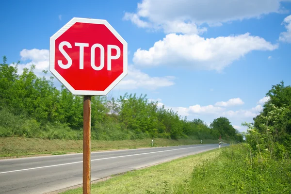 Стоп знак на пустой дороге — стоковое фото