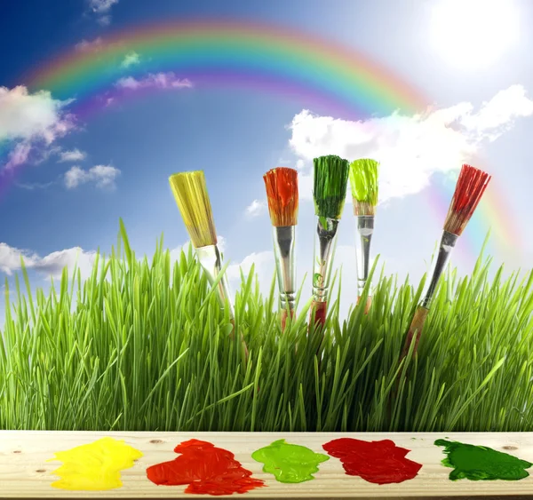 Brushes colors of nature with rainbow and sun — Stock Photo, Image