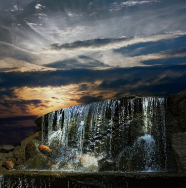 Waterfall at night at sunset clipart