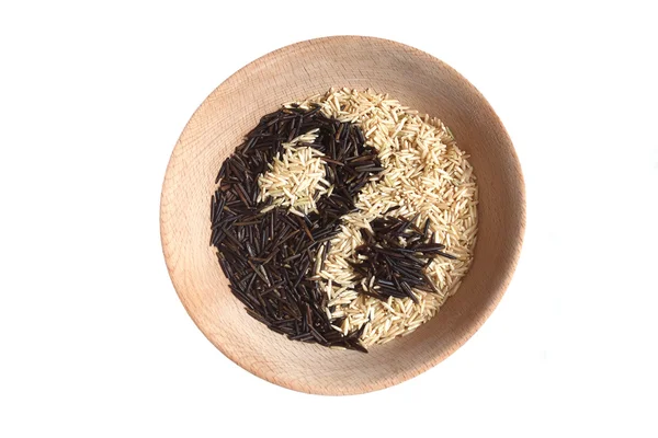 Signo de yin y yang hecho de arroz en un tazón de madera . Imagen De Stock