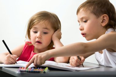 Careful brother shows to his smaller sister the color of felt-tip pen which is better for drawing clipart