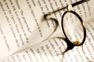 Image of glasses lying on a book clipart