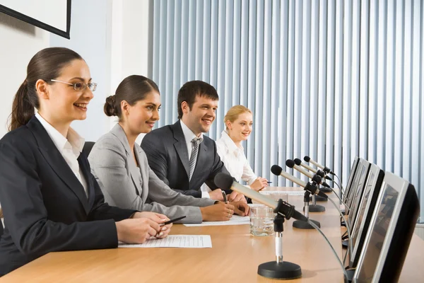 Foto von Geschäftsleuten, die bei einem Seminar am Tisch sitzen — Stockfoto