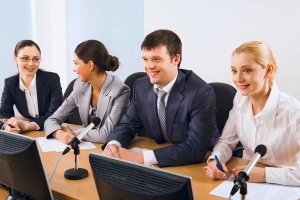 Foto von Geschäftsleuten, die bei einem Seminar am Tisch sitzen — Stockfoto