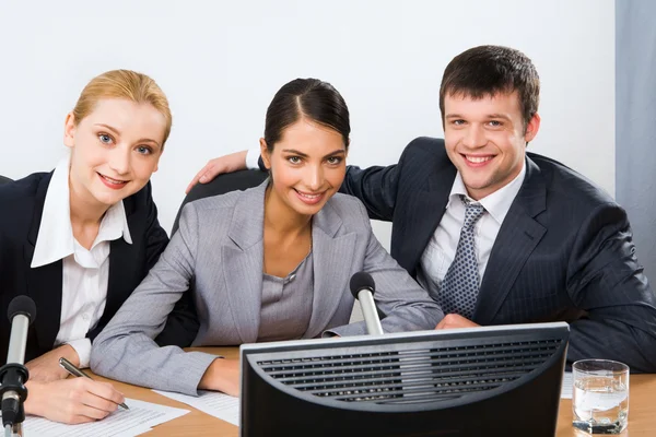 Portrait of confident professionals sitting at the table with microphones — Stock Photo, Image