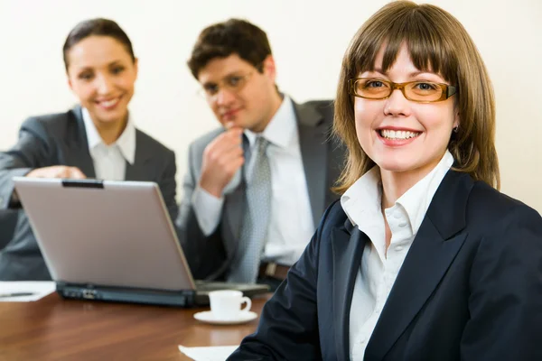 Mujer inteligente en un segundo plano los colegas en la oficina —  Fotos de Stock