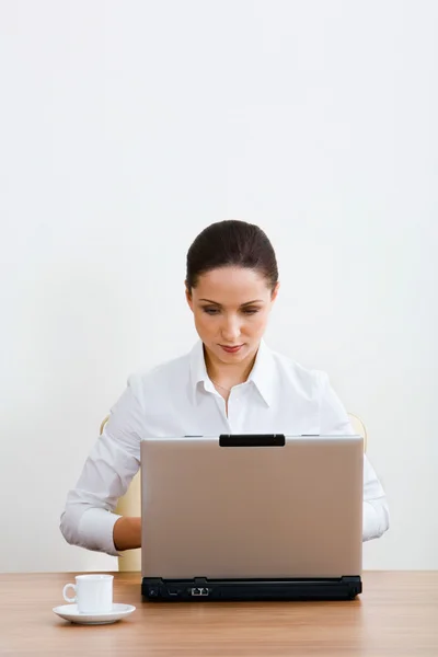 Joven mujer de negocios elegante mira a su computadora portátil y piensa en nuevos planes — Foto de Stock