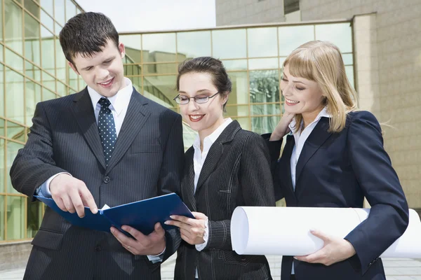 Portrait of successful businesspeople discussing a project near a office building — Stock Photo, Image