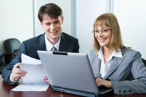 Imagen de dos trabajando mirando la pantalla del ordenador portátil en la oficina —  Fotos de Stock