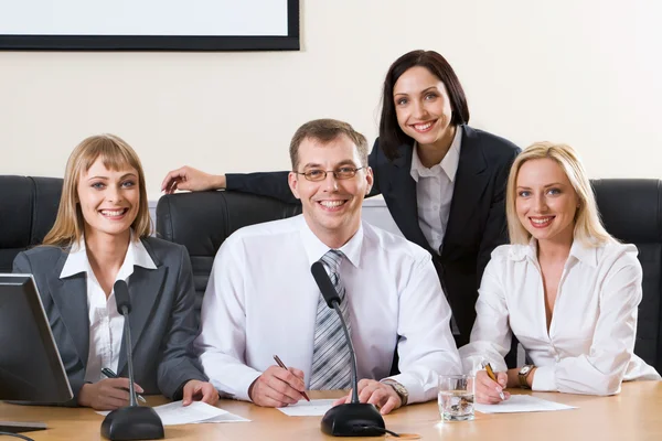 Successful smiling sitting in a row — Stock Photo, Image